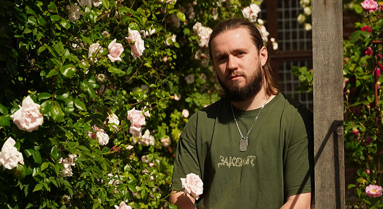 Porträtt på stridssjukvårdaren Andrii, iförd grön t-shirt.