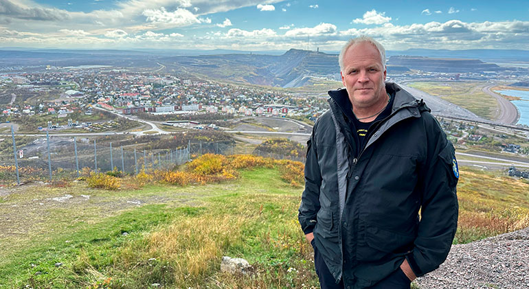 Räddningschefen i Kiruna, Thomas Winnberg, står på toppen av berget Luossavaara. Nedanför honom ser man Kirunas gamla del, gruvberget och nya E10.