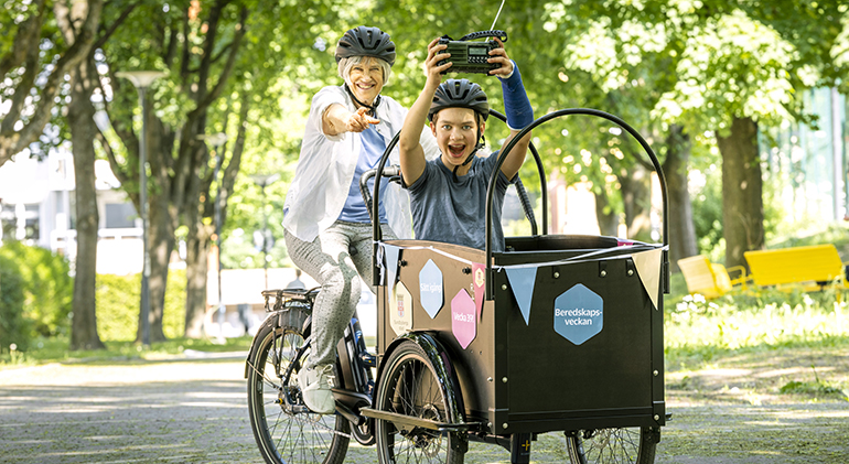 Äldre kvinna och pojke på cykel